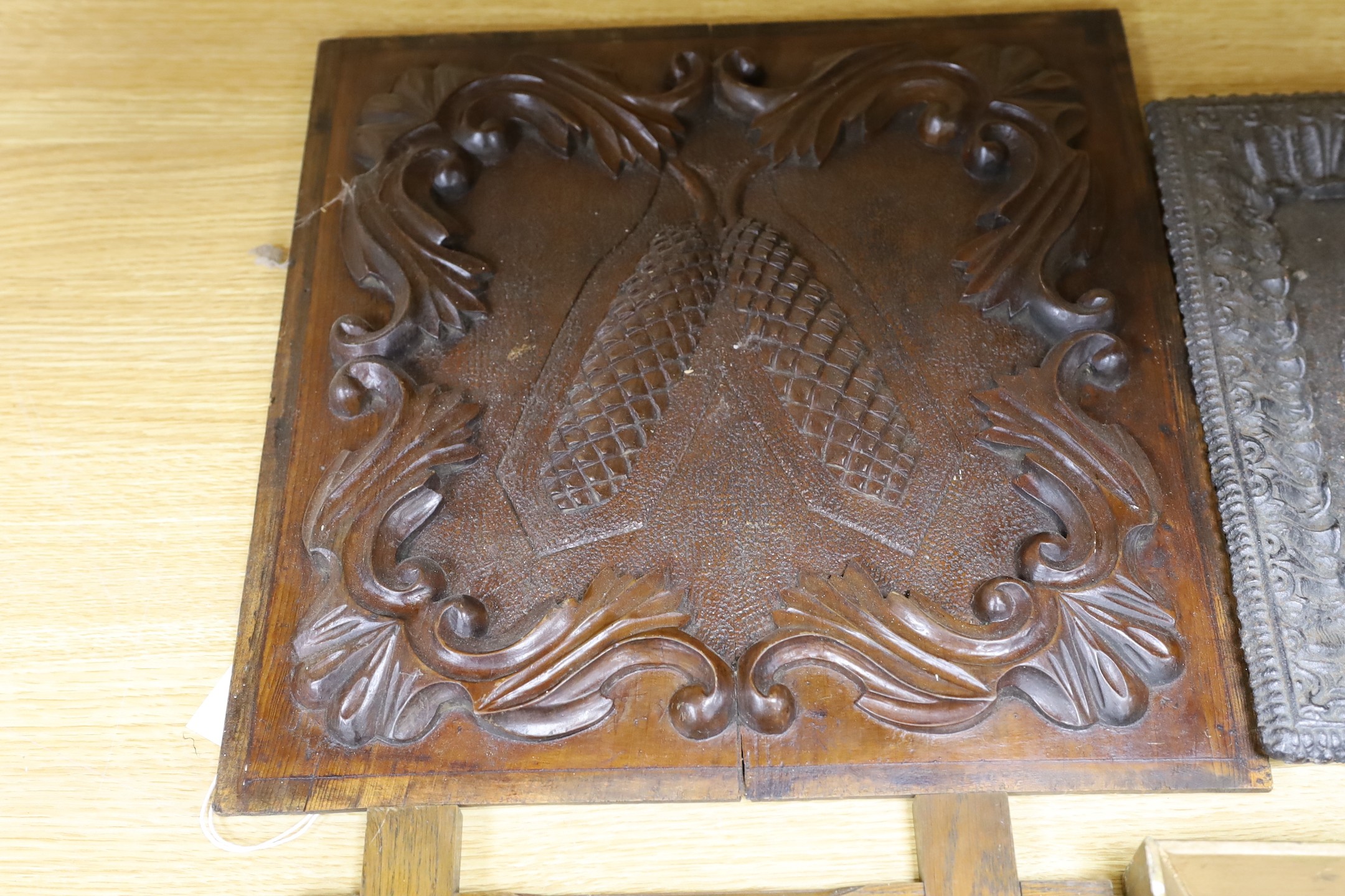 Three assorted cast metal panels together with a carved walnut panel, 39x40cm